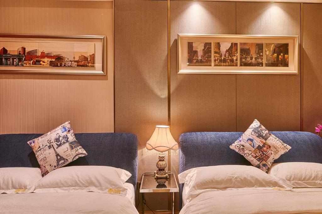 a bedroom with two beds and a table with a lamp at Heefun International Apartment - Zhujiang New Town FuLi Brand New World Plaza in Guangzhou
