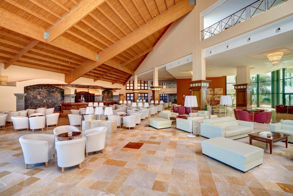a large lobby with white chairs and tables at Hipotels Natura Palace Adults Only in Playa Blanca