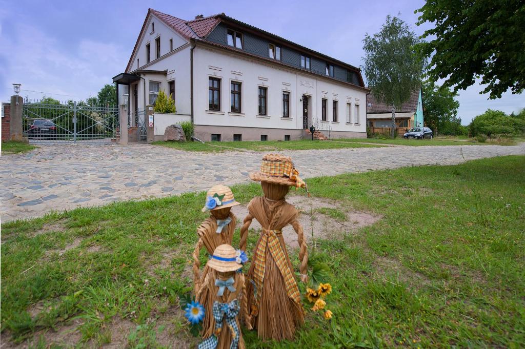 een standbeeld van een vrouw en twee kinderen voor een huis bij Pension Kuhn in Klietz