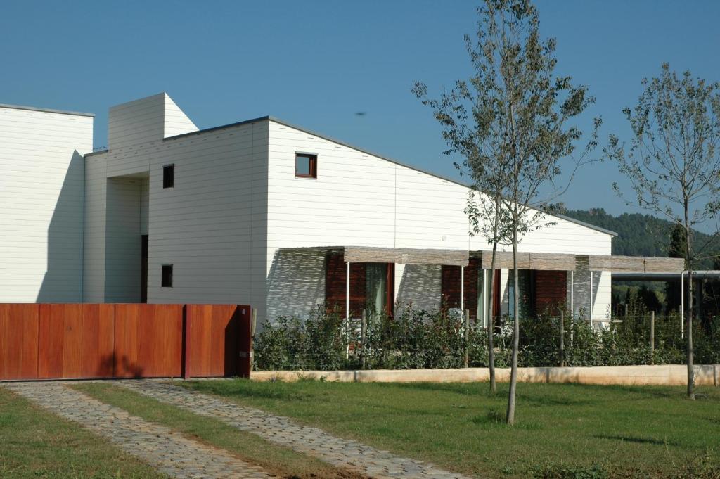 Una casa blanca con un árbol delante. en La Fustana en Maia de Montcal