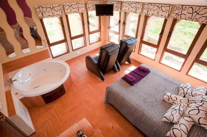 Schlafzimmer mit einem Bett, einer Badewanne und einem Waschbecken in der Unterkunft Casa Rural Caseta de l' Hort in Villafranca del Cid