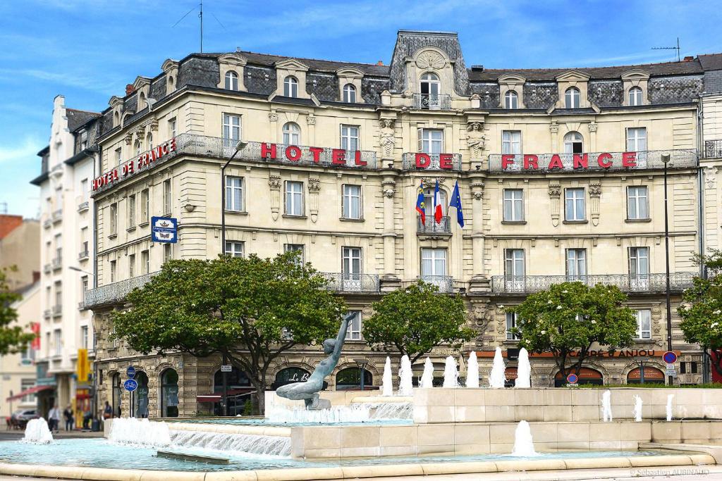 a hotel with a fountain in front of a building at Hôtel De France in Angers