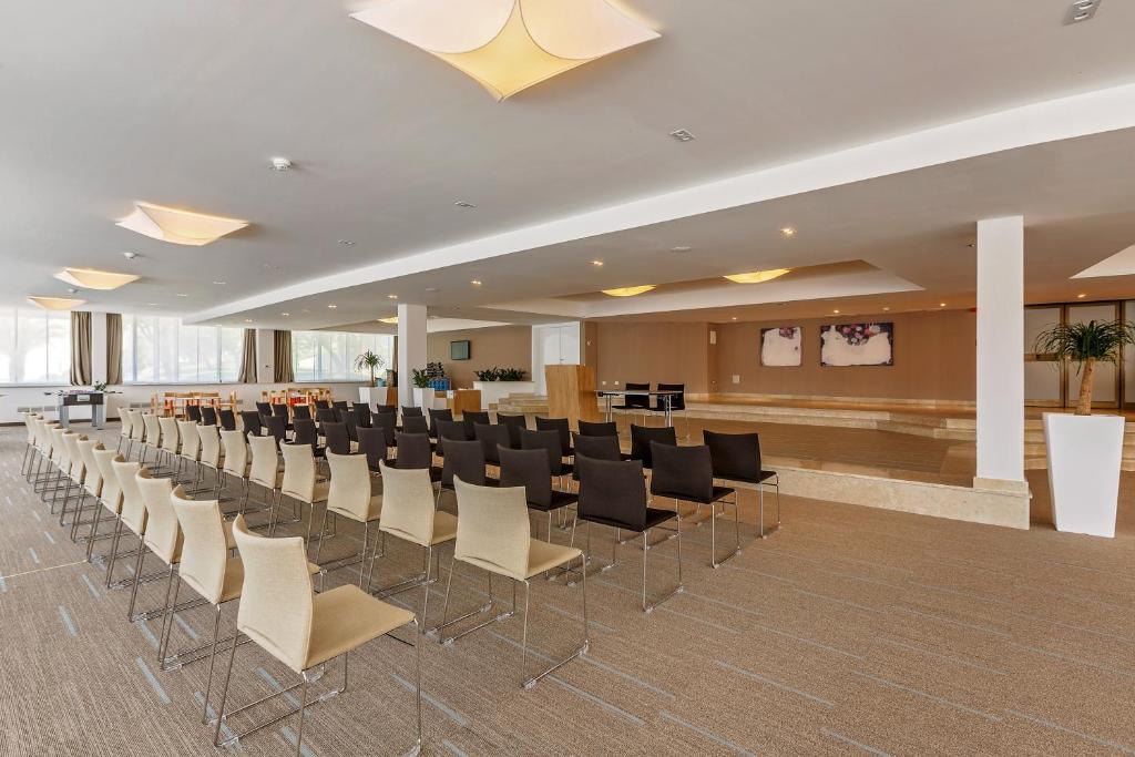a conference room with a row of chairs and a bar at Hotel Zorna Plava Laguna in Poreč