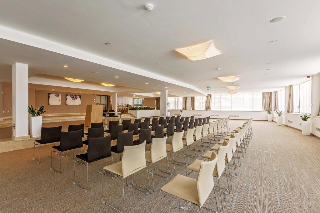 a large room with rows of chairs and a bar at Hotel Zorna Plava Laguna in Poreč