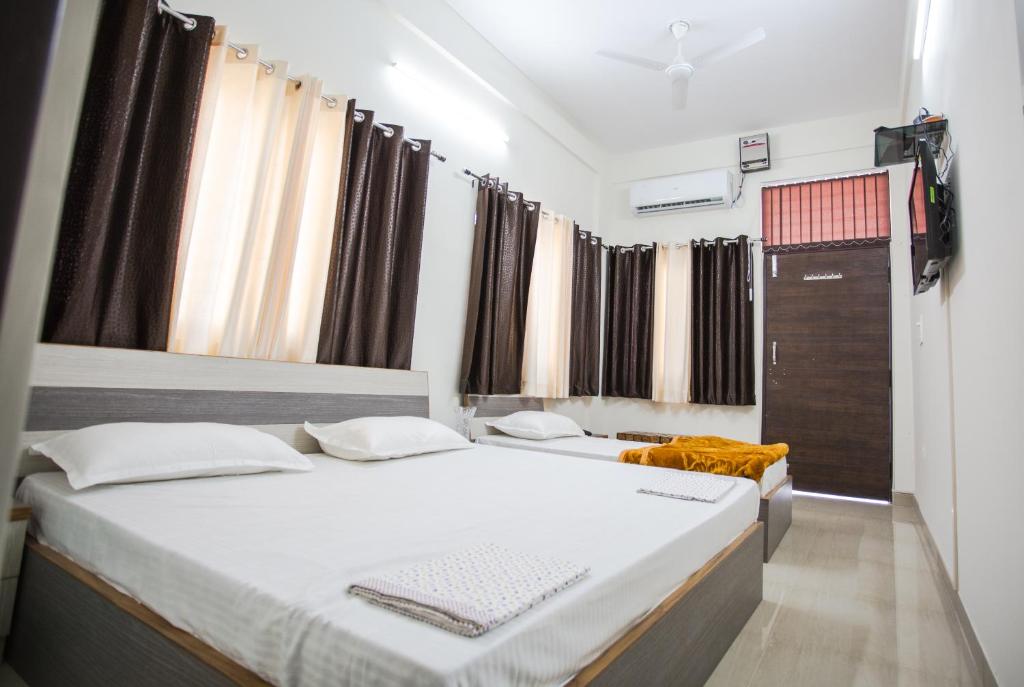 德拉敦Hotel Shiv Kripa的有两张床和一扇窗户的卧室