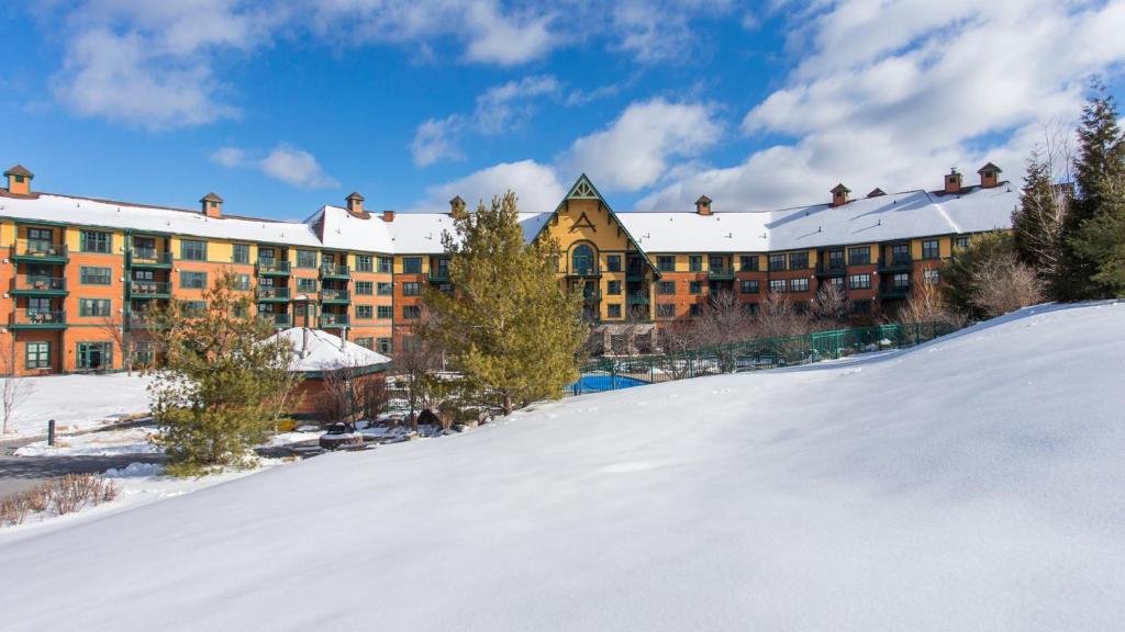 un complejo en la nieve con una pendiente cubierta de nieve en The Appalachian at Mountain Creek, en Vernon