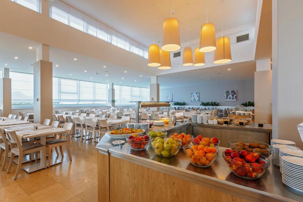 a restaurant with bowls of fruit on a counter at Hotel Zorna Plava Laguna in Poreč