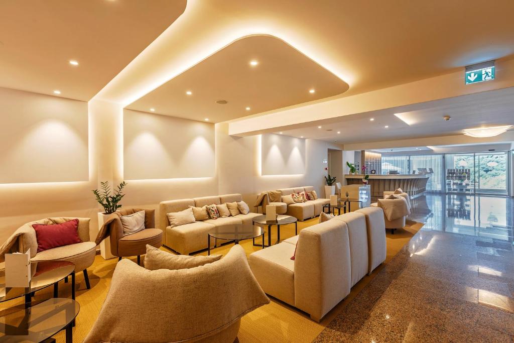 a waiting room with couches and tables at Hotel Zorna Plava Laguna in Poreč