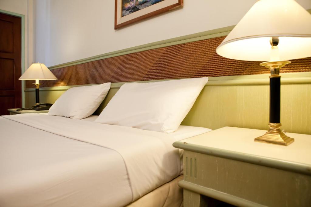 una camera d'albergo con due letti e una lampada di Tanyong Hotel a Narathiwat