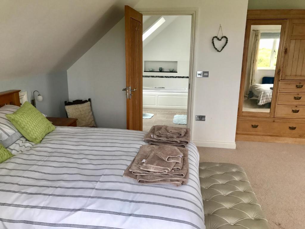 a bedroom with a large bed and a mirror at Family Run Farm B&B in Gooseham