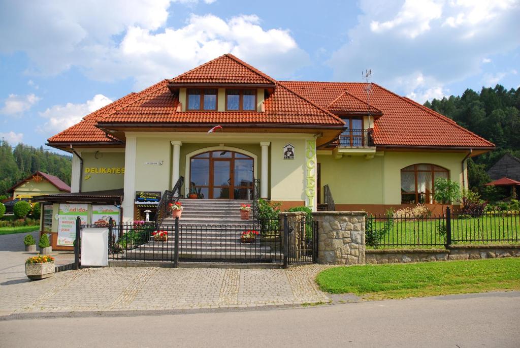 uma pequena casa amarela com um telhado vermelho em U Kuby em Korbielów