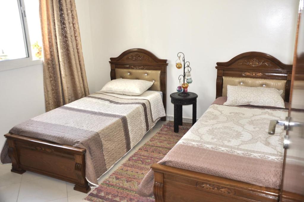 two beds sitting next to each other in a bedroom at Bri Apartment in Casablanca