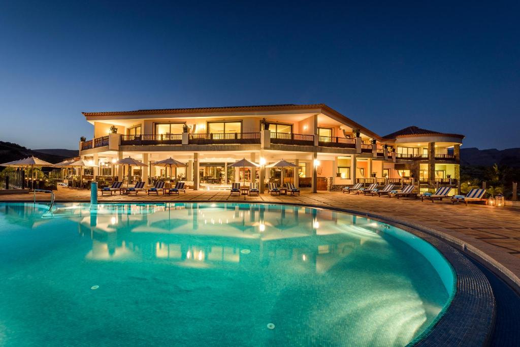 una gran piscina frente a un edificio en Casa León Royal Retreat en Maspalomas