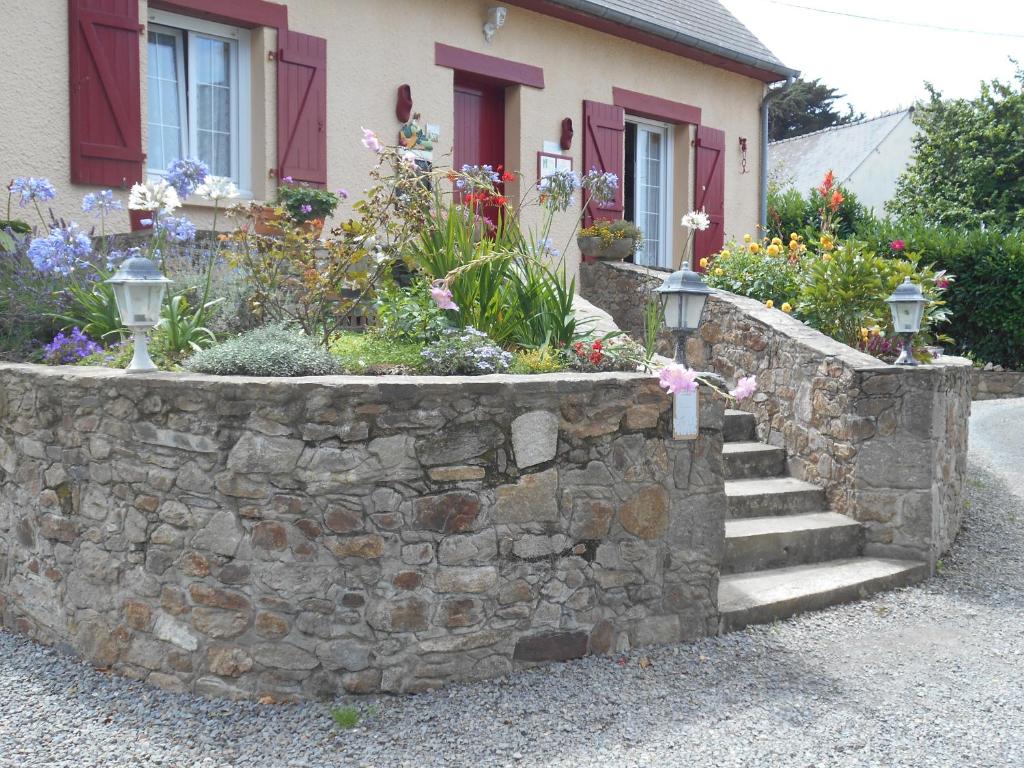 a stone retaining wall with stairs in front of a house at Fée Morgane - Chambres in Saint-Coulomb