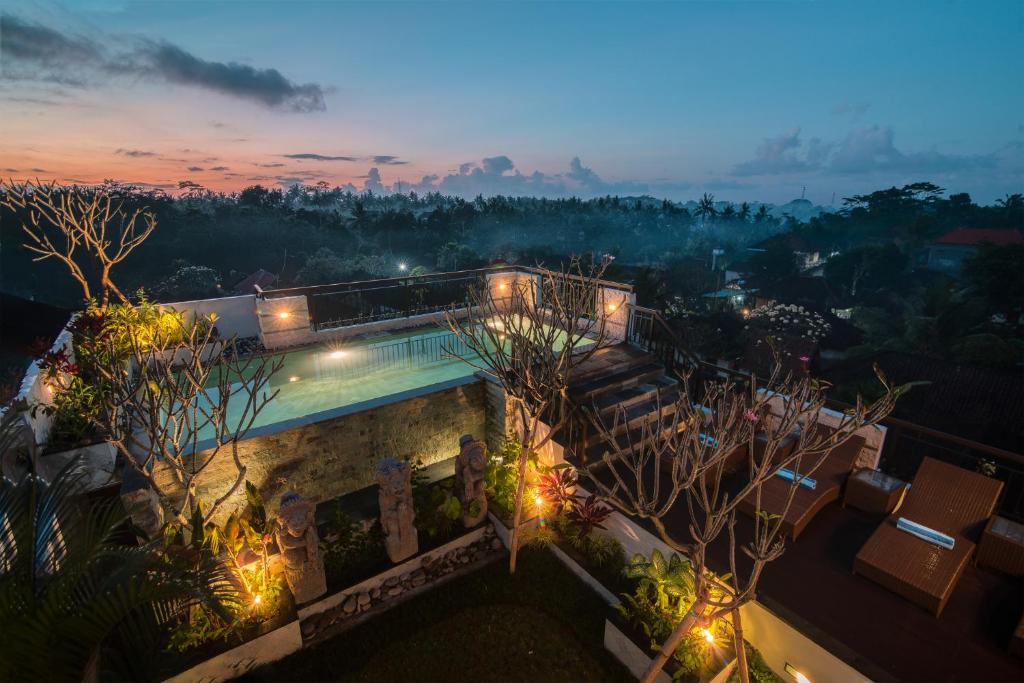 a villa with a swimming pool at night at Pecatu Ubud Guest House in Ubud