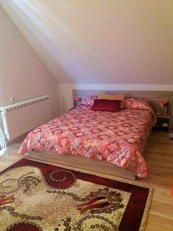 1 dormitorio con 1 cama con edredón rojo y alfombra en Full Rooms en Kyustendil