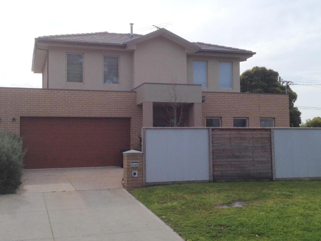a house with a fence and a garage at Luxurious 3 Bedroom Townhouse. 900mt Walk To The Rosebud's Best Beach in Rosebud