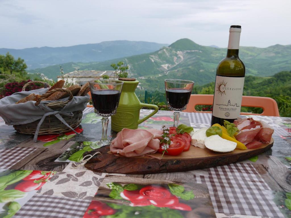 uma mesa com uma garrafa de vinho e um prato de comida em Il Monte Farmhouse em Torricella Peligna