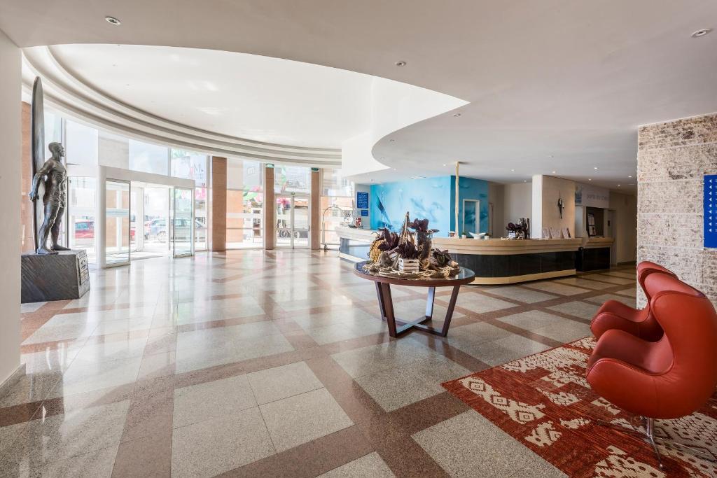 a lobby with a statue and a table in a building at TRYP by Wyndham Lisboa Caparica Mar in Costa da Caparica