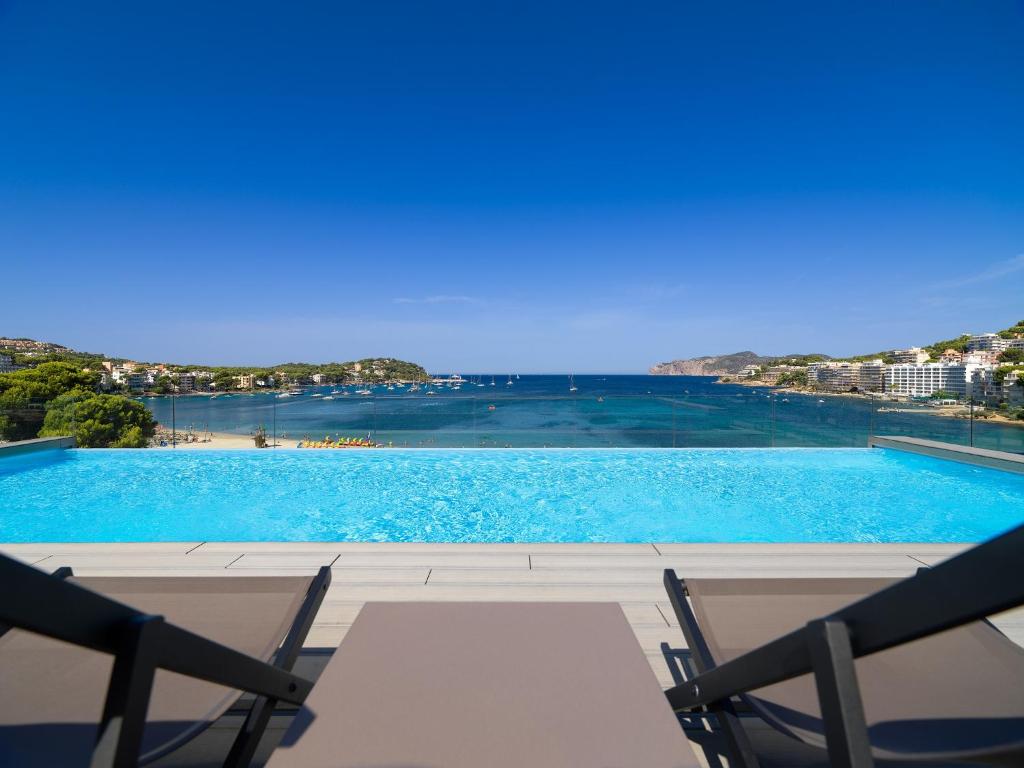 a view of a swimming pool with two chairs at H10 Casa del Mar in Santa Ponsa