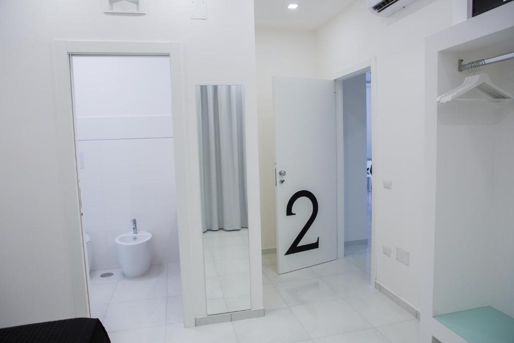 ein weißes Bad mit einer Tür mit der Nummer zwei in der Unterkunft Melissa B&B in Castellabate