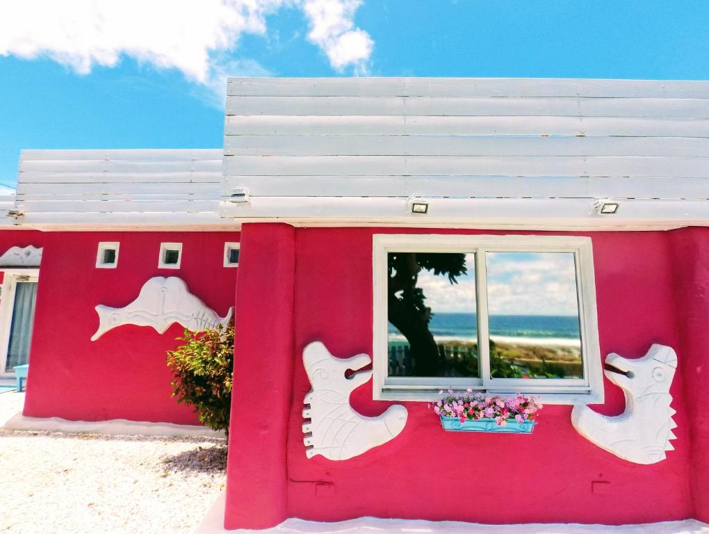 a pink building with a window in front of it at 灣境海邊小屋 in Eluan