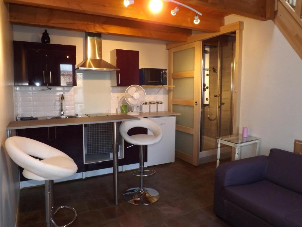 una cucina con bancone e due sgabelli in una stanza di Etablissement Roussel a Saint-André-de-Sangonis
