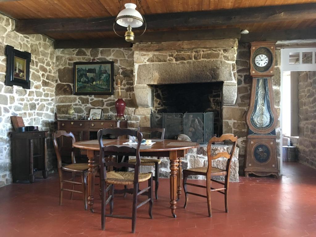 comedor con mesa, sillas y chimenea de piedra en Villa Aman An Ty, en Belz