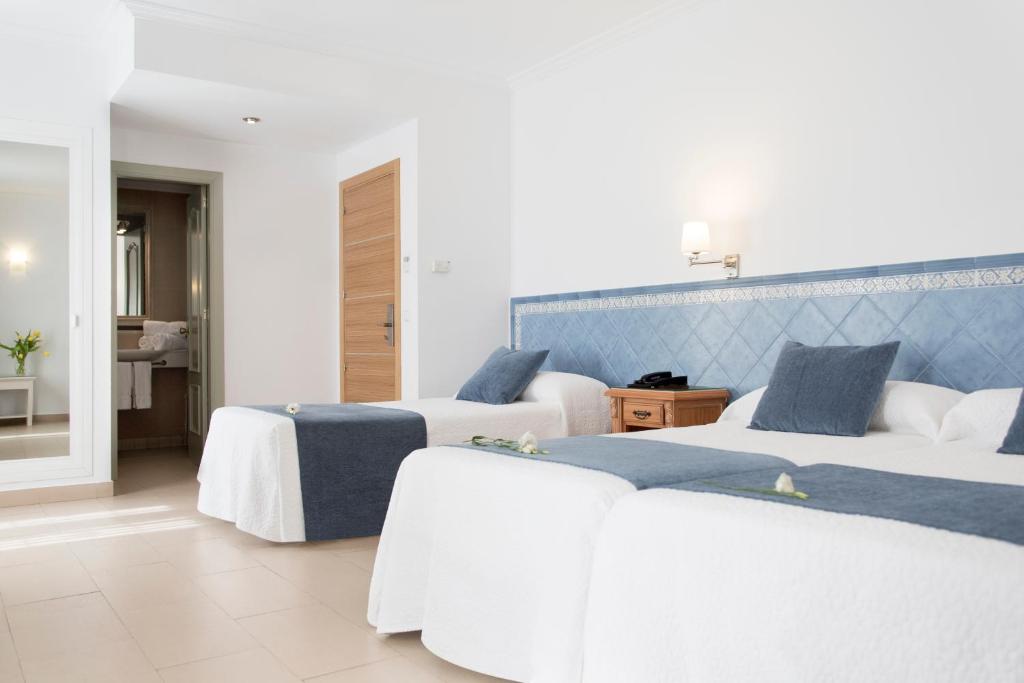 a bedroom with two beds with blue and white at Hotel Plaza Cavana in Nerja