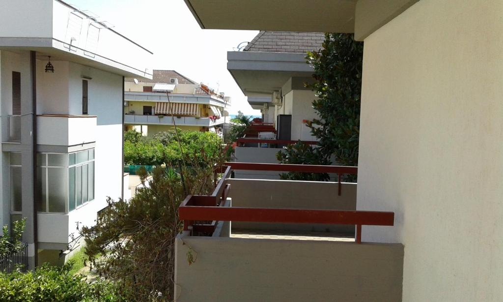 eine Reihe roter Bänke an der Seite eines Gebäudes in der Unterkunft casa vacanze Martinsicuro in Martinsicuro