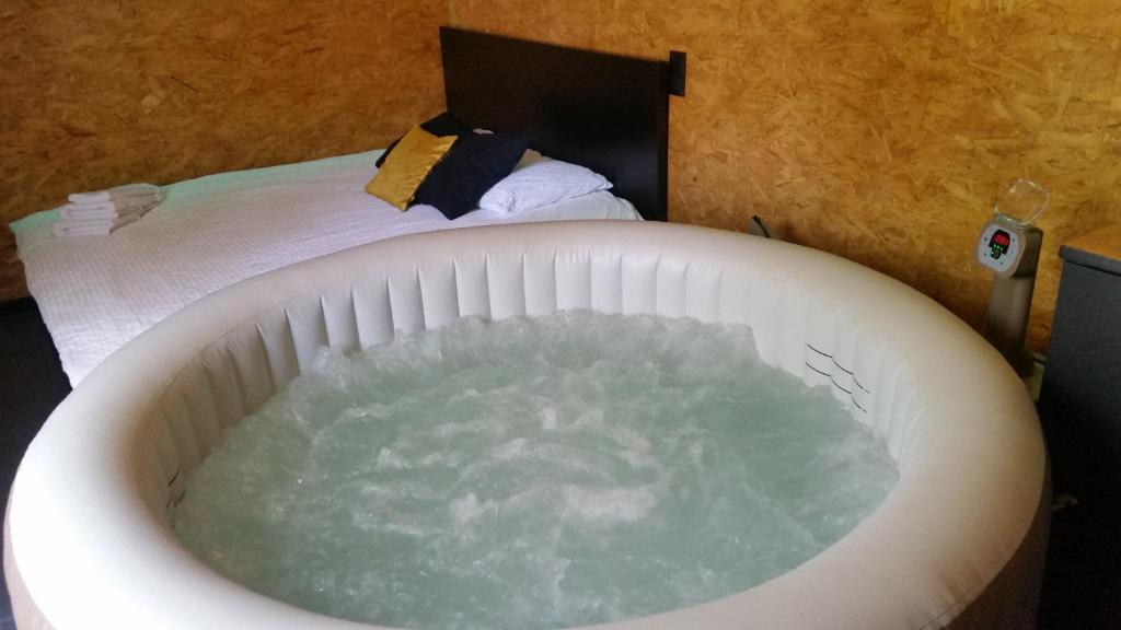 コルベイユ・エソンヌにあるCabane Zenのベッドの横に水を入れたバスタブが備わります。