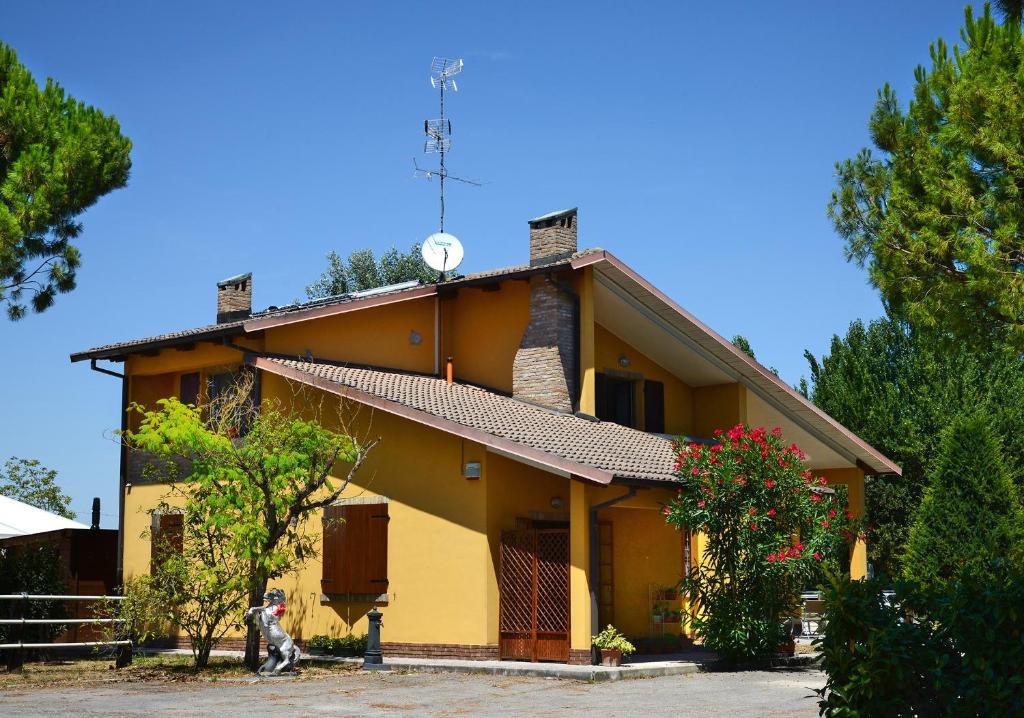 a yellow house with a clock on the roof at Real BB Balsamico in Bastiglia