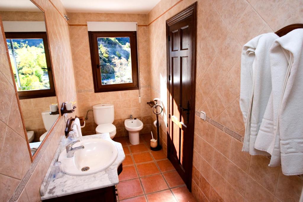 un baño con lavabo e inodoro en Hostal Mulhacen, en Trevélez