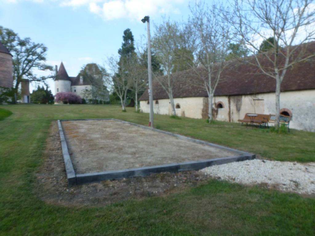 a large yard with a bench and a building at Gite Des Etangs in Paulnay