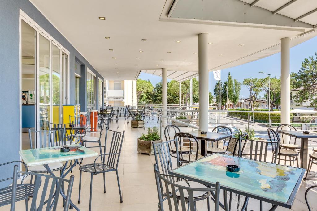 a patio with tables and chairs on a building at Hotel Ambassador in Caorle