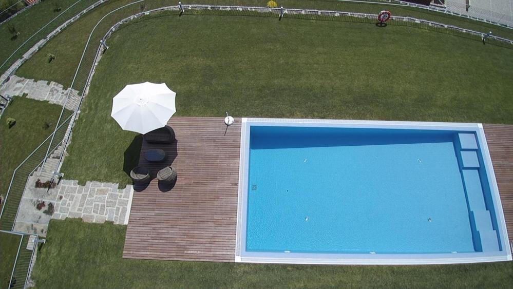 an overhead view of a swimming pool with an umbrella at Hotel Rural Quinta das Quintães in Penafiel