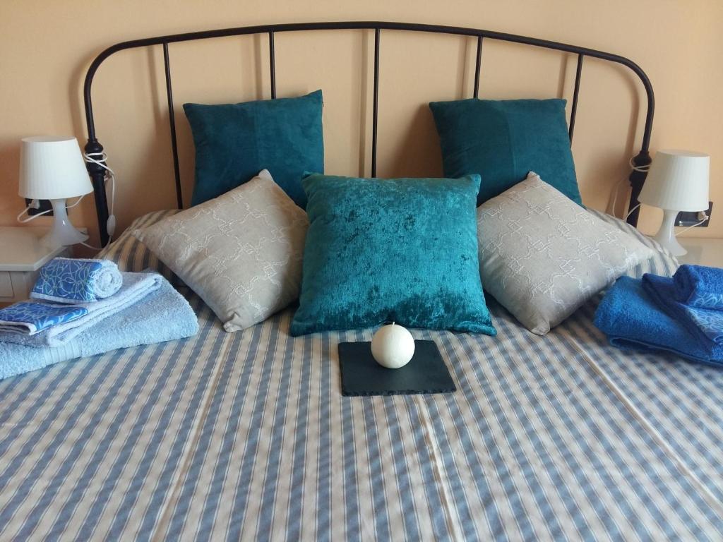 a bed with blue pillows and a table on it at WONDERVIEW GALIMBERTI 18 in Montepulciano