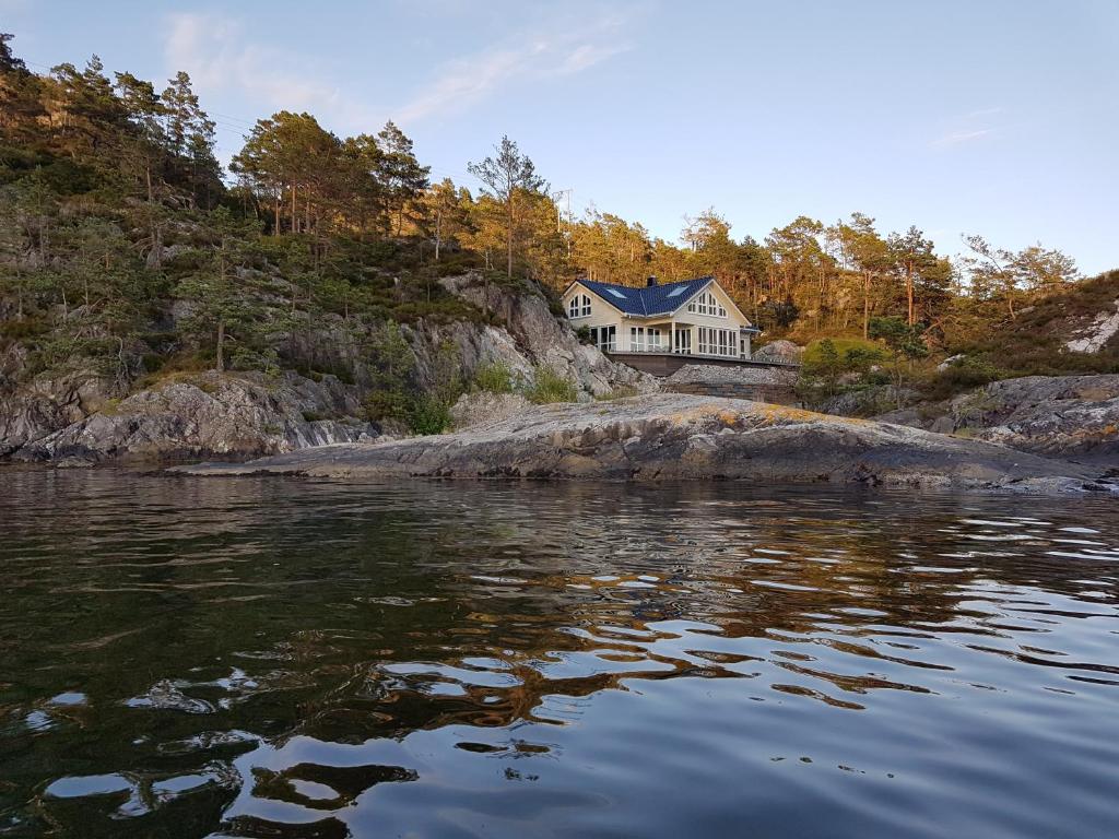 a house on the shore of a body of water at Ropeid Villa Fjordferie in Ropeid