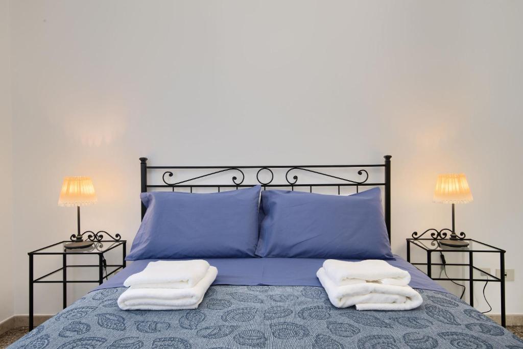 1 dormitorio con 1 cama azul y 2 toallas en Appartamento turistico di Lulù, en Roma