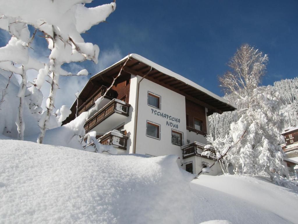 ein schneebedecktes Gebäude neben einem Schneehaufen in der Unterkunft Tschatscha Nova in Kappl