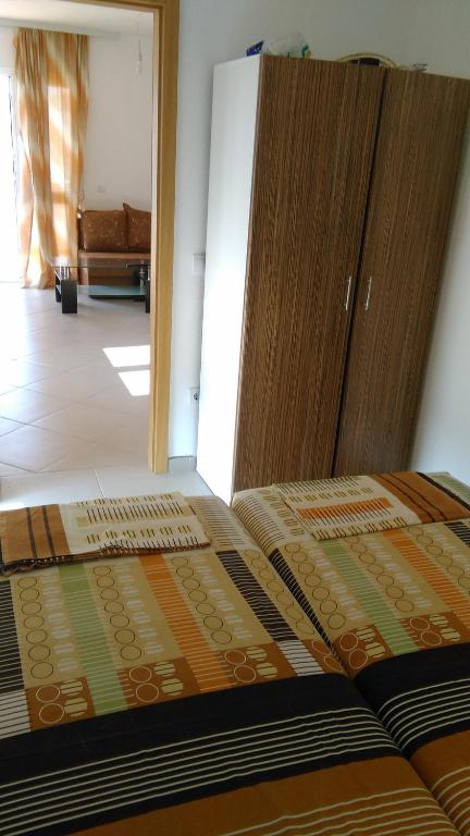 a bedroom with a bed with a wooden cabinet at Aparmani Family 1 in Sutomore