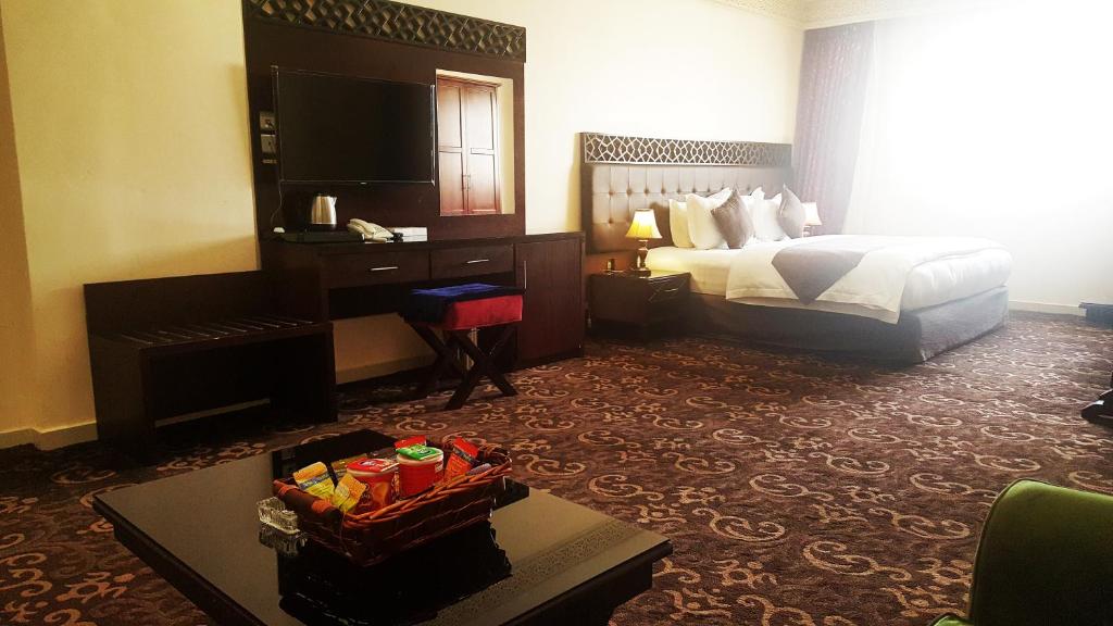 um quarto de hotel com uma cama e uma mesa em Procare Apart hotel em Jeddah