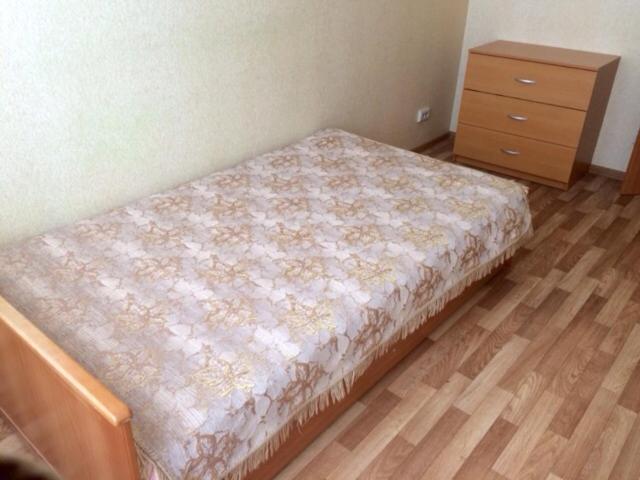 ヴェリーキー・ノヴゴロドにあるApartment on Voskresenskiy 1のドレッサー付きの部屋、ベッドルーム1室のベッド1台分です。