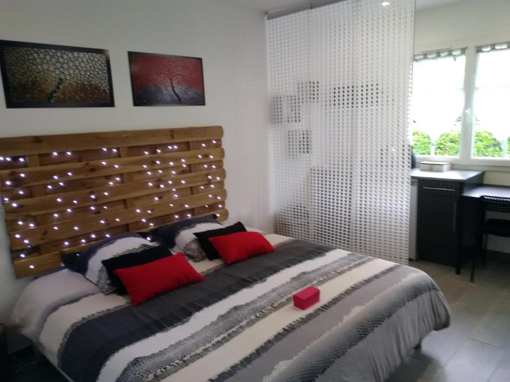 a bedroom with a large bed with a wooden headboard at Chambre d'Hôtes Les Macarons de Tata in Sainte-Eulalie