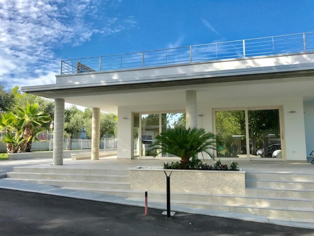 a house with a porch and stairs in front of it at Camping San Michele in Moniga