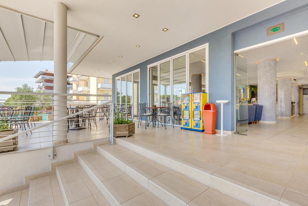 a lobby of a building with tables and chairs at Hotel Ambassador in Caorle