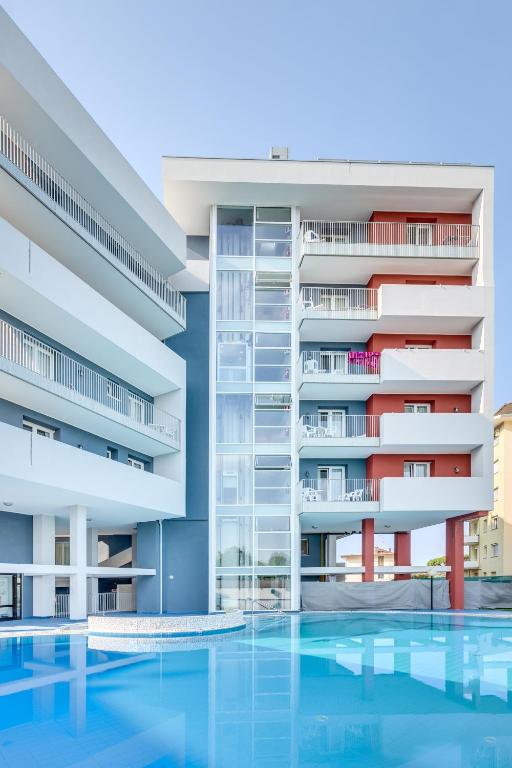 an image of an apartment building with a swimming pool at Hotel Ambassador in Caorle