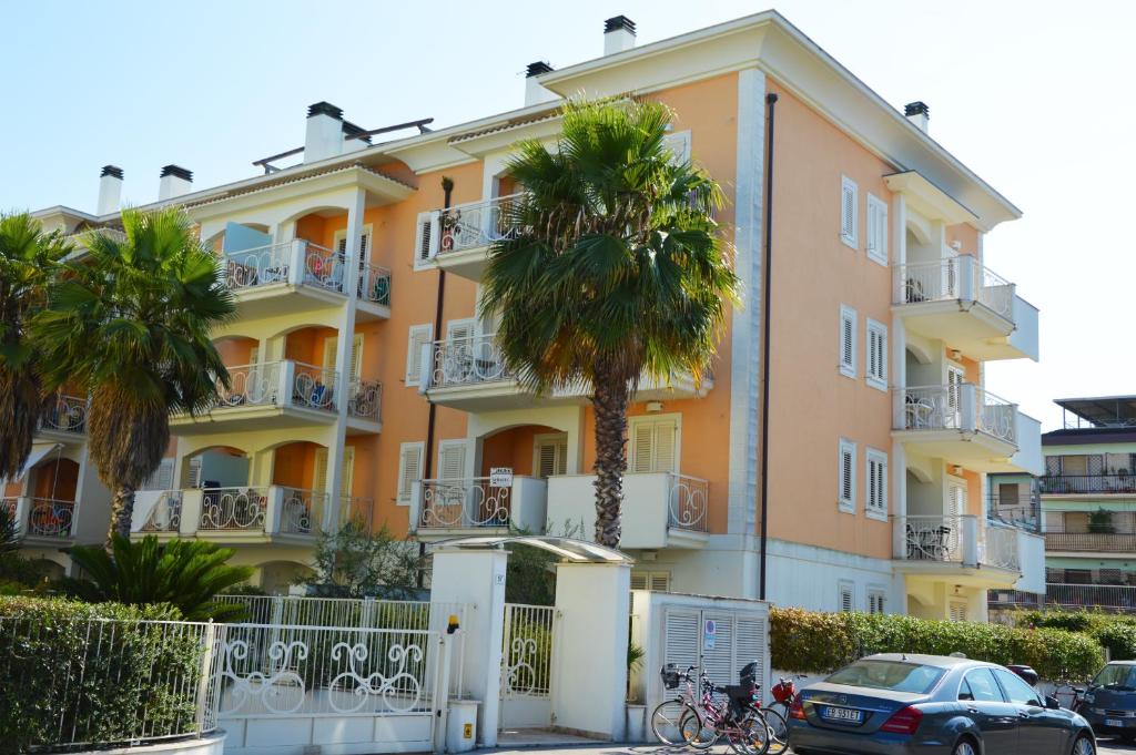 un edificio con una palmera delante de él en Giardino sul mare en San Benedetto del Tronto