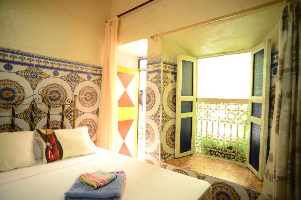 a bedroom with a bed and a window with at Riad Espagne in Marrakech