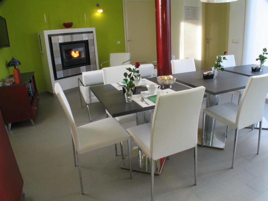 a dining room with a table and chairs and a fireplace at 6 Porte Guesthouse in Mantova